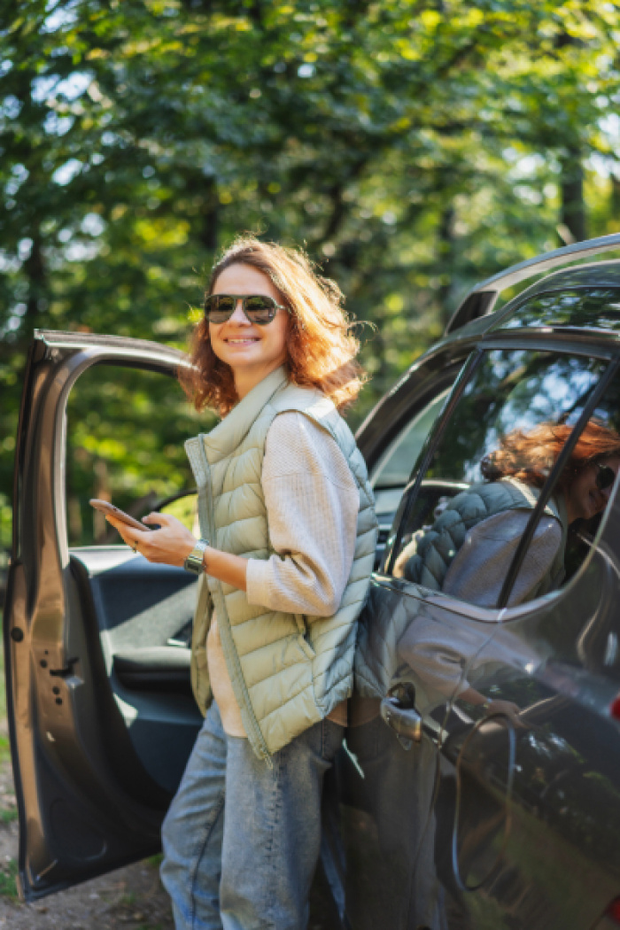 Woman smiling by her car