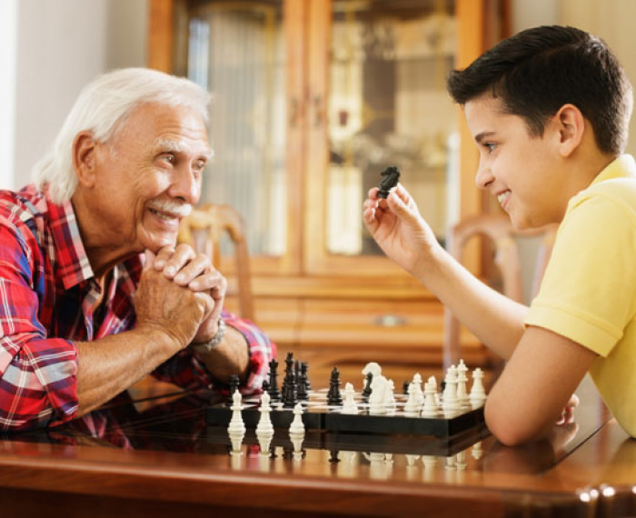 Grandfather and grandson playing chess.