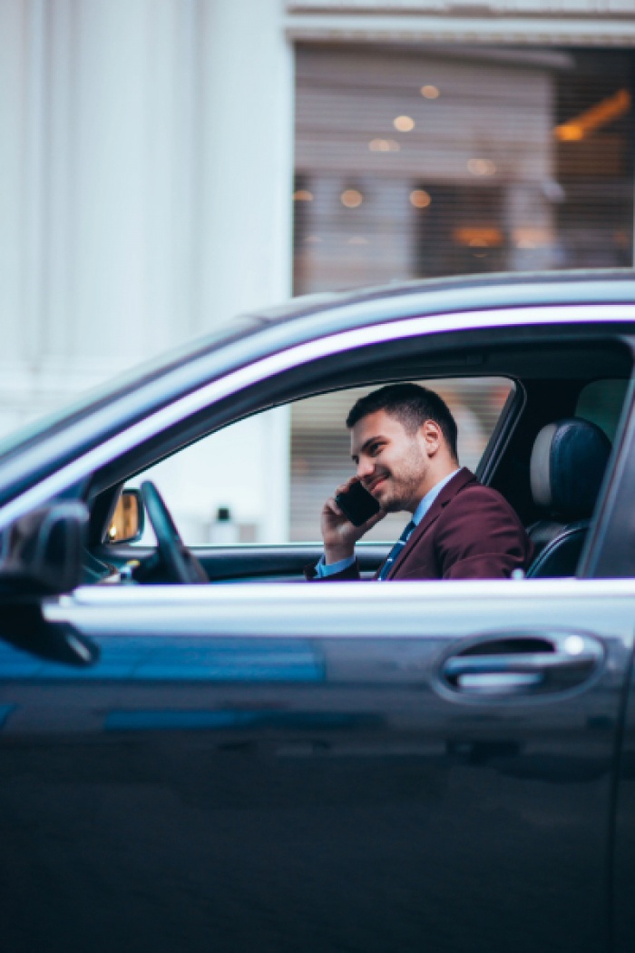 Businessman taking a phone call in his car