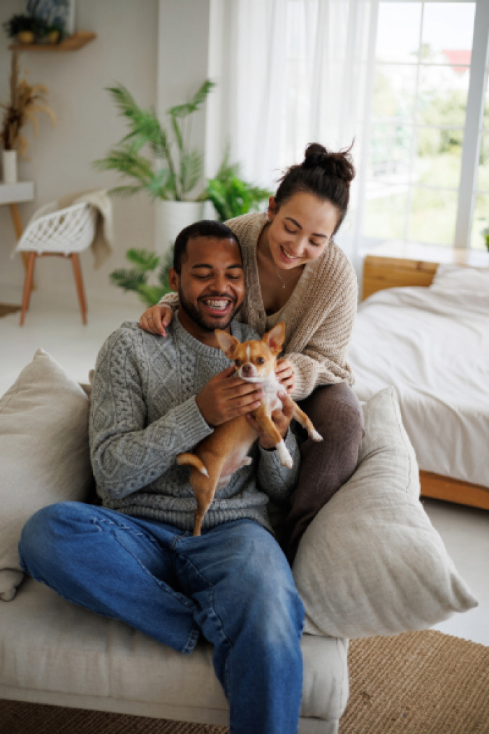 Happy couple at home with their dog