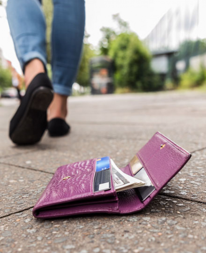 Person losing their wallet on the ground.